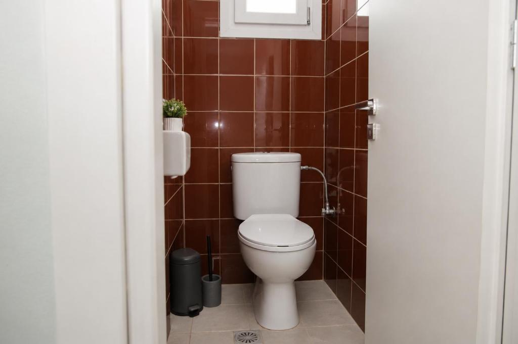 The compact lower-floor WC with a high frosted window and bold red wall tiles