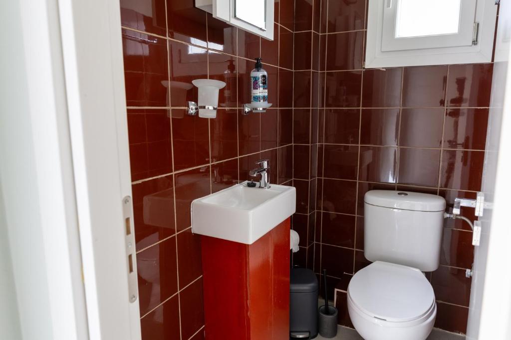 The modern WC on the lower floor: deep red tiles, white basin and chrome fittings